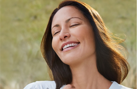 Restylane® Contour patient smiling naturally in an open meadow